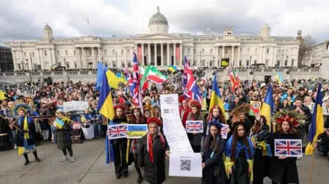 Mu kibanza Trafalgar Square c'i Londres mu Bwongereza, abari mu myiyerekano bari bambaye ibitambara bifise amabara y'ibendera rya Ukraine 