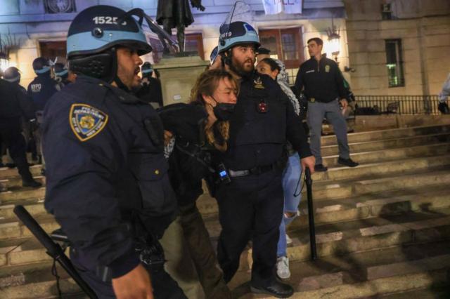 دو پلیس زن جوانی را که نقاب زده بود دستگیر کرده‌اند
