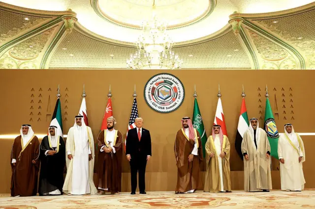 (من اليسار إلى اليمين) ولي عهد البحرين الأمير سلمان بن حمد آل خليفة، وأمير الكويت الشيخ مشعل الأحمد الصباح، وأمير قطر الشيخ تميم بن حمد آل ثاني، ونائب رئيس الوزراء العماني السيد أسعد بن طارق، والرئيس الأمريكي دونالد ترامب، وولي العهد السعودي الأمير محمد بن سلمان، وملك البحرين حمد بن عيسى آل خليفة، يلتقطون صورًا تذكارية مع القادة خلال قمة قادة دول مجلس التعاون الخليجي في فندق ريتز كارلتون، الرياض، المملكة العربية السعودية، في 14 مايو 2025.