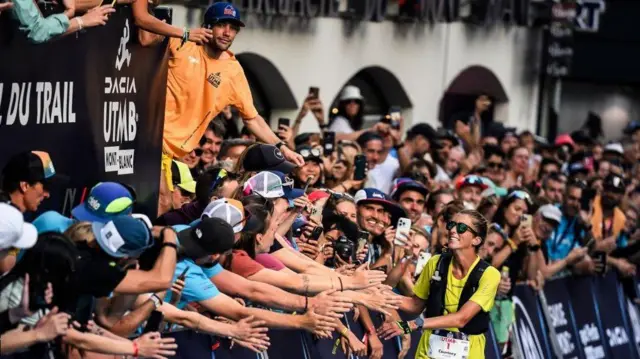 خوش و بش داوالتر با تماشاگران در حالی که با فاصله بیش از ۴۰ دقیقه نسبت به زن بعدی و رتبه ۲۵ در میان ۲۶۹۳ دونده به خط پایان UTMB نزدیک میشود