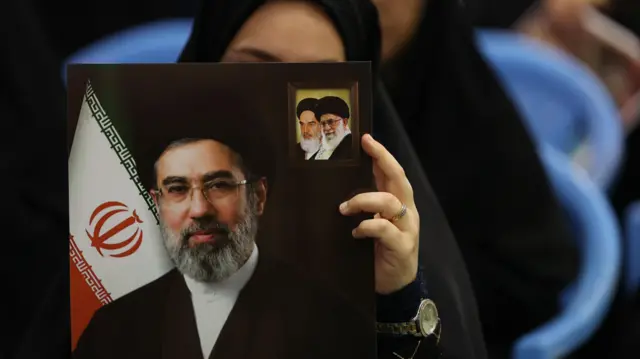 امرأة تحمل صورة المرشد الأعلى الإيراني آية الله مجتبى خامنئي خلال مراسم تأبين لضحايا الحرب الإيرانية الأمريكية الإسرائيلية في مسجد في طهران.