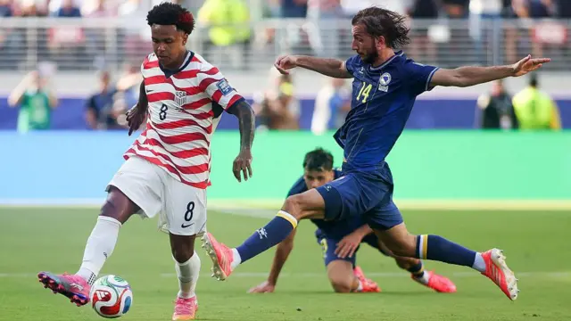 Weston McKennie, de Estados Unidos, disputa un balón con Ivan Sunjic, de Bosnia y Herzegovina y vestido de azul, durante el partido de dieciseisavos.