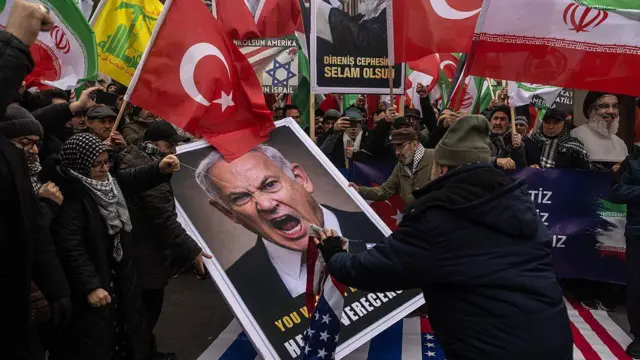 ellerinde türkiye, iran islam cumhuriyeti ve hizbullah bayrakları olan çoğu erkek kalabalık, ortada bulunan binyamin netanyahu resmini parçalıyor. 