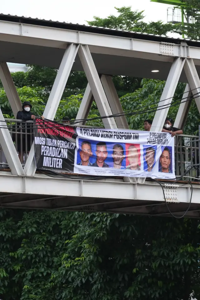 Spanduk yang memasang wajah pelaku versi Puspom TNI dan versi Polda Metro Jaya