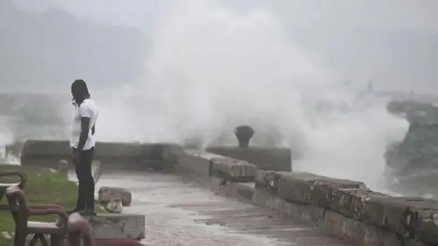 Чоловік спостерігає, як хвилі б'ються об набережну Кінгстона, поки на острів наближається ураган "Мелісса", 27 жовтня