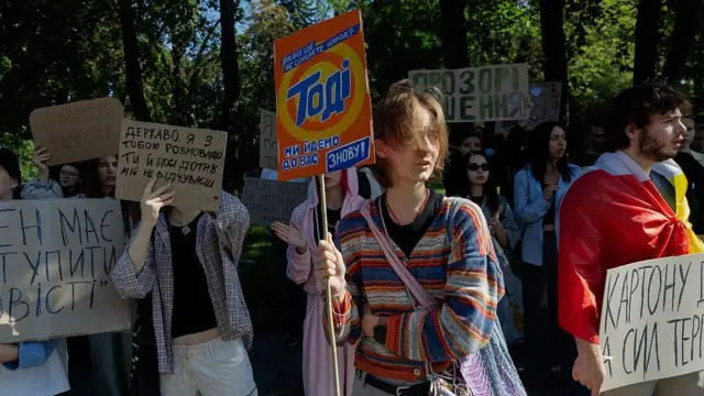 Молодые люди с картонными плакатами.