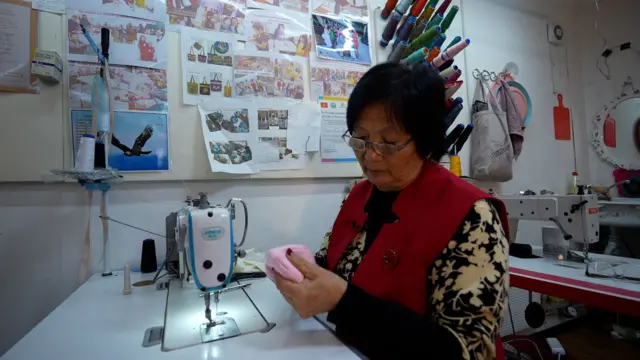 Шайыр Сагынбаева жасалма эмчек тигип отурат. Башында сааттап алышса, азыр он беш мүнөттө эле тигип коём дейт