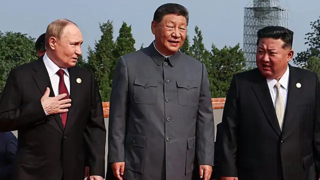 (Soldan sağa) Rusya Devlet Başkanı Vladimir Putin, Çin Devlet Başkanı Şi Jinping ve Kuzey Kore lideri Kim Jong Un ile birlikte yürürken.