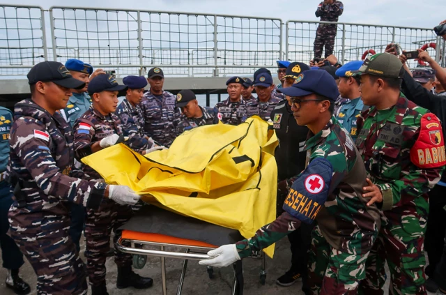 Prajurit TNI AL memindahkan jenazah dari atas KRI Tongkol-813 ke ambulans di Pelabuhan Pusri Ketapang, Banyuwangi, Jawa Timur, Minggu (06/07).