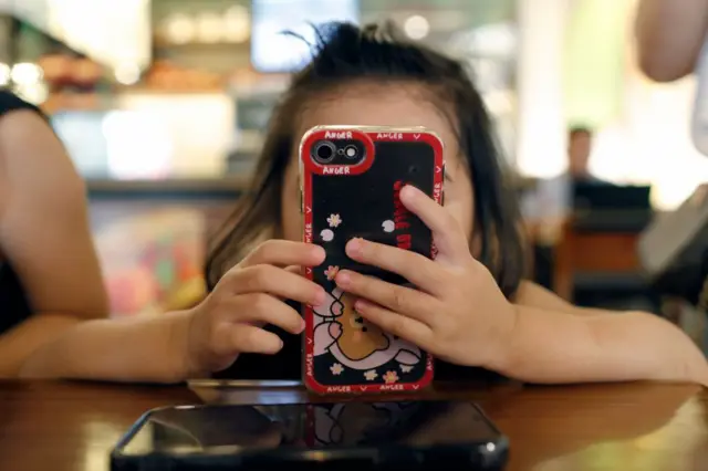  Bé gái dùng điện thoại 