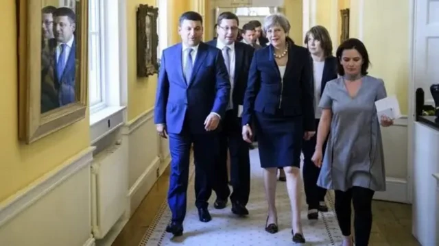 На зустрічі з прем'єр-міністеркою Великої Британії Терезою Мей влітку 2017 року. Попереду в коридорі іде Гройсман, а ззаду нього - Станіслав Єжов