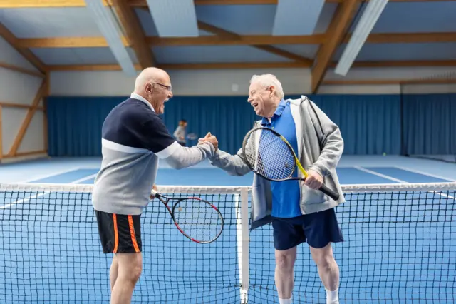 Dos hombres mayores jugando al tenis