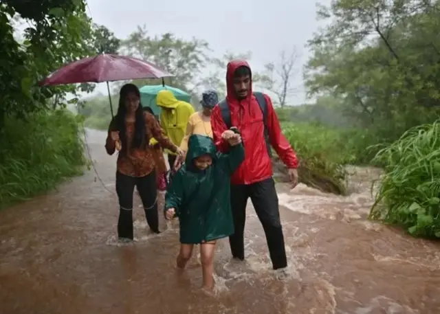 Des personnes se déplaçant dans une zone inondée.