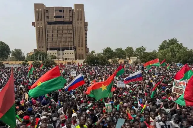 Supporters of Captain Ibrahim Traore carry Burkina Faso and Russian flags for di rally to support Traore for Place de la Nation, Ouagadougou, 30 April 2025.