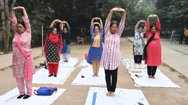 በቡድን በመሆን ዮጋ የሚሰሩ ሴቶች