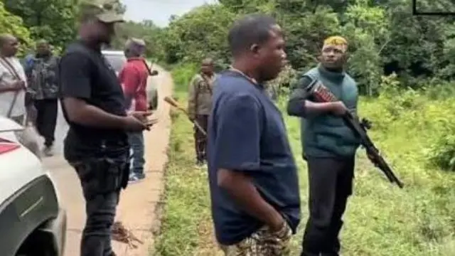 Sunday Igboho ati awọn ẹmẹwa rẹ to mu oniruuru ibọn lọwọ, duro si ẹba oju popo, igbo nla kan wa niwaju wọn pẹlu awọn mọto ti wọn gbe wa