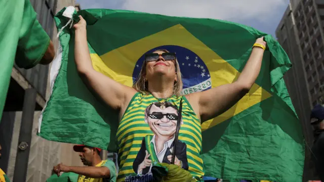 Mulher com blusa com rostopixbet modo clássicoBolsonaro e ergue bandeira do Brasil 