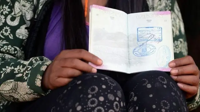 हातमा पासपोर्ट लिएकी एक महिला