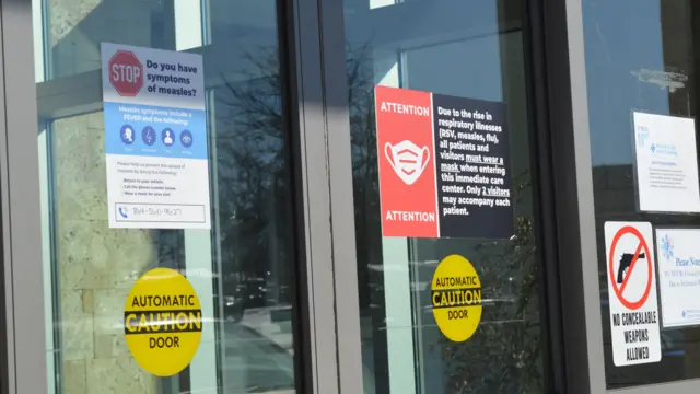 Las puertas de atención de urgencia muestran una señal de advertencia de sarampión.