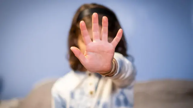 Niña con una pijama que pide parar con la mano.