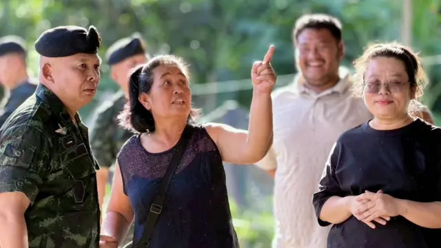 ထိုင်းစစ်တပ်အရာရှိတစ်ဦးကို ဒေသခံတစ်ဦးက မြန်မာဘက်က လက်နက်ကြီးကျည်ကျကွဲတဲ့နေရာကို ညွှန်ပြနေတဲ့မြင်ကွင်း