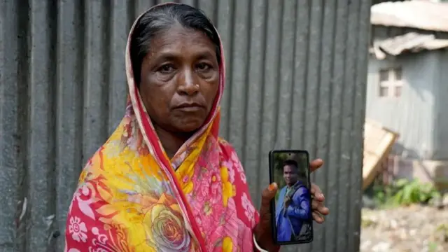 Shefali Rani Das akiwa na picha ya mwanawe, Dipu, akiwa amevaa suti mpya baada ya kupata kazi yake