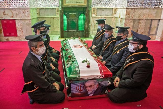Soldados iranianos ajoelhados diante do caixão do responsável pelo programa nuclear de Teerã