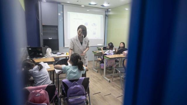 Stella en el salón de clase con unas alumnas