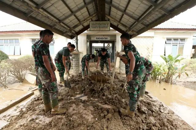 Prajurit TNI bersama relawan membersihkan lumpur yang mengenangi ruang rawat inap dan fasilitas medis Rumah Sakit Umum Daerah (RSUD) Aceh Tamiang pascabanjir luapan Sungai Tamiang di Aceh Tamiang, Aceh, Sabtu (20/12/2025).