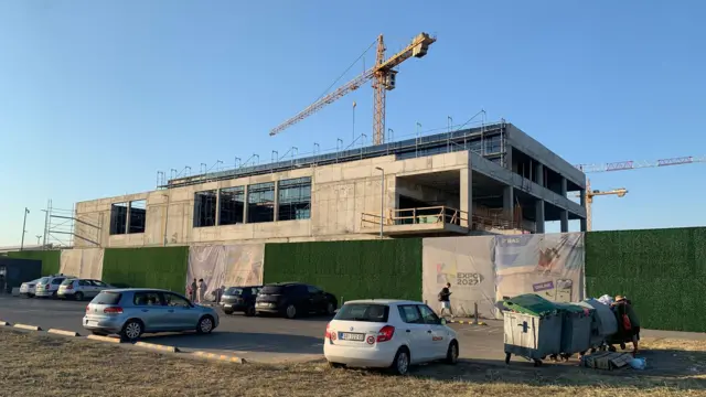 Nekoliko automobila ispred objekta koji se gradi