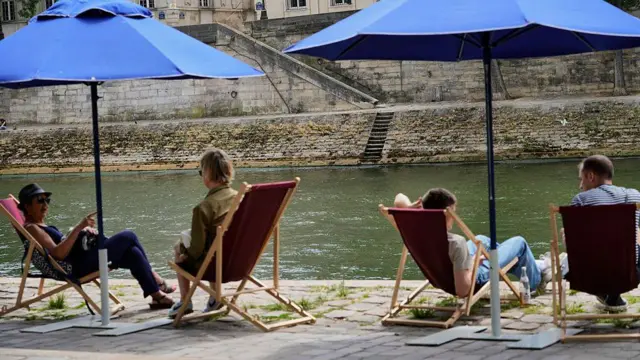 Varias personas descansando en la rivera del río Sena