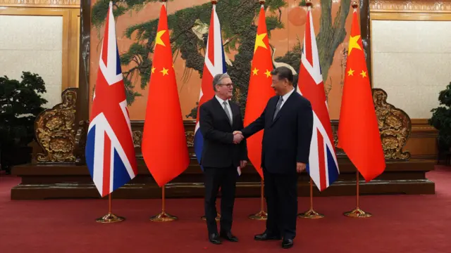 基尔·斯塔默(左)与习近平(右)在北京人民大会堂握手,背景是两国国旗(29/1/2026)