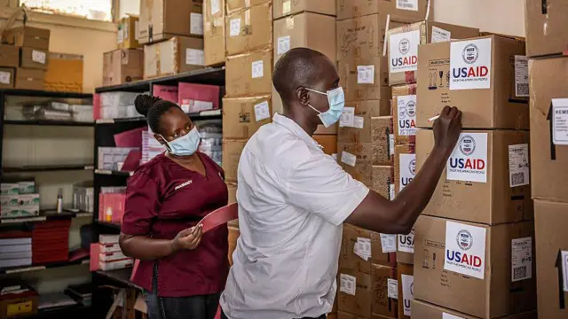 Wani ma'aikacin ƙaramin asibiti a Kenya ke duba ƙwalayen kayan tallafin USAID