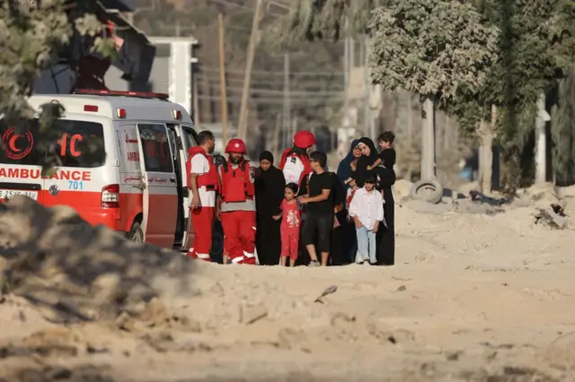 Израилдин чабуулунан качкан палестиналык аялдар балдары менен Кызыл Жарым Айдын кызматкерлерине корголоп турат