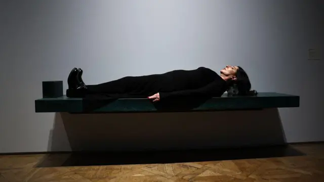 Marina Abramovic posa sobre una de sus obras de arte, titulada "Dragón Verde" durante una sesión fotográfica en la Royal Academy of Arts (RA).