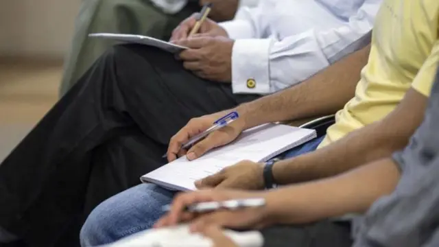 ஒருவர் நோட்டு புத்தகத்தில் எழுதுவது போன்ற ஒரு புகைப்படம் 