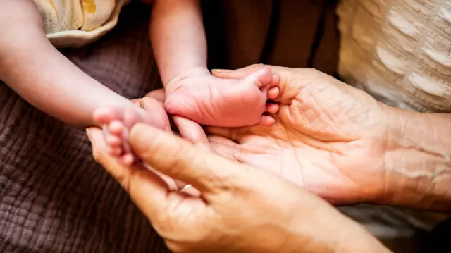 A 2-week-old girl and her grandmother in her 60s.
