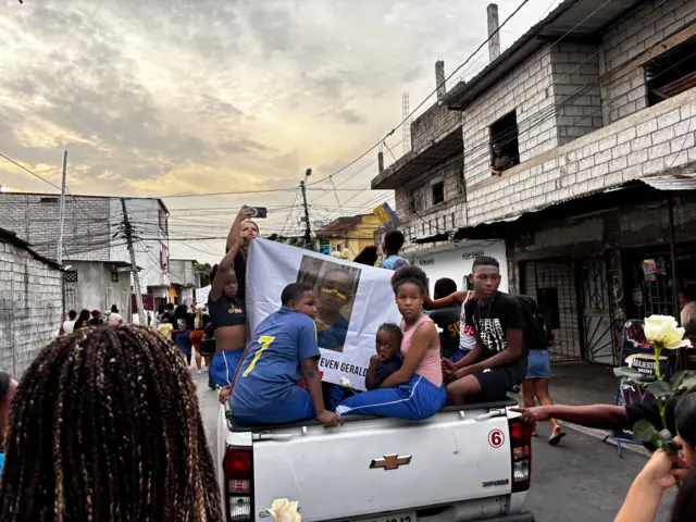 Varias personas subidas en una camioneta con un retrato de Steven.