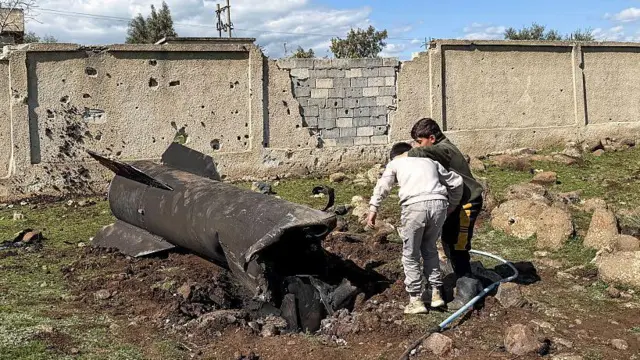 Des enfants syriens inspectent les débris d'une roquette iranienne qui aurait été interceptée par les forces israéliennes dans la zone rurale sud de Quneitra, près des hauteurs du Golan.