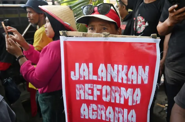 Seorang pengunjuk rasa membawa poster tuntutan.