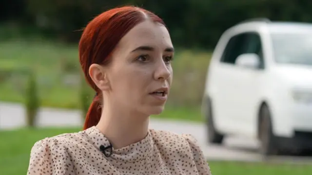 Дівчина з мідно-червоним волоссям у сукні в дрібний горошок