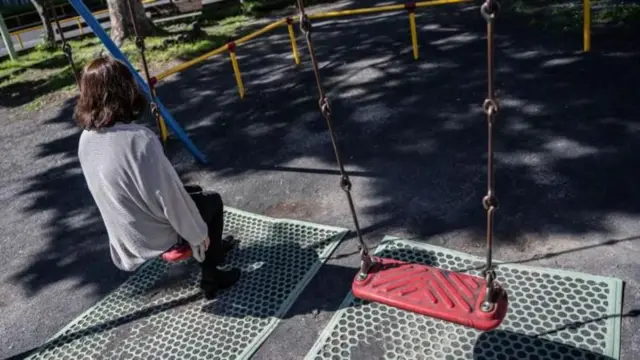 ਪਾਰਕ ਵਿੱਚ ਝੂਲੇ ਉੱਤੇ ਬੈਠੀ ਇਕੱਲੀ ਔਰਤ