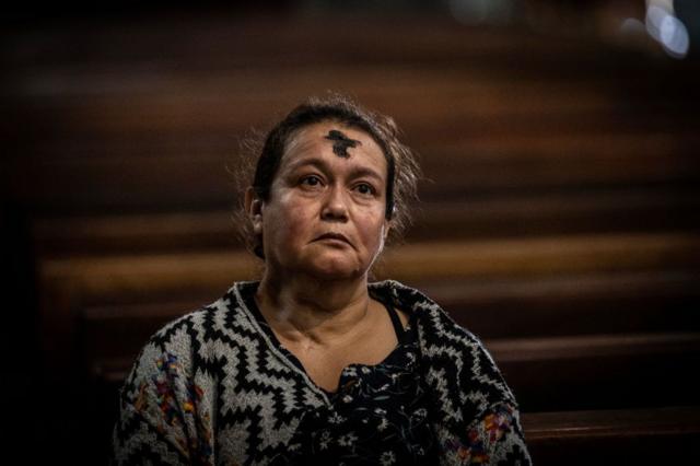 Una mujer reza durante el Miércoles de Ceniza en Bogotá el 14 de febrero de 2024.