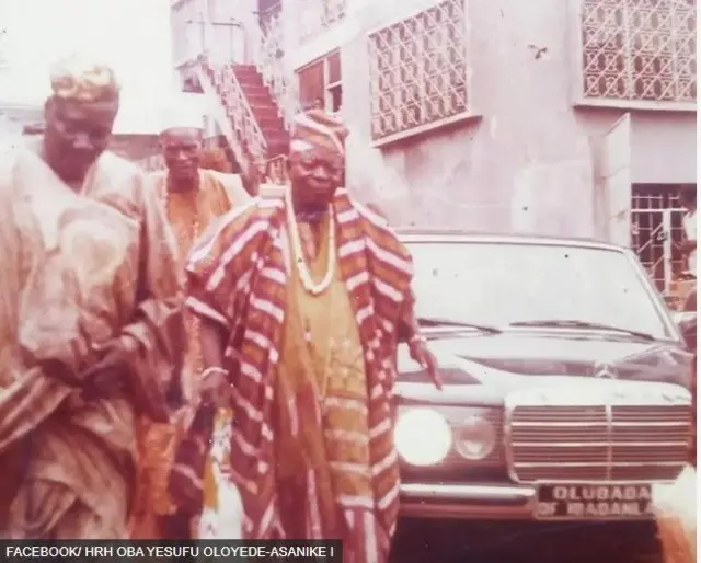 Aworan Ọba Aṣankẹ pẹlu awọn oloye kan niwaju ọkọ ayọkẹlẹ kan