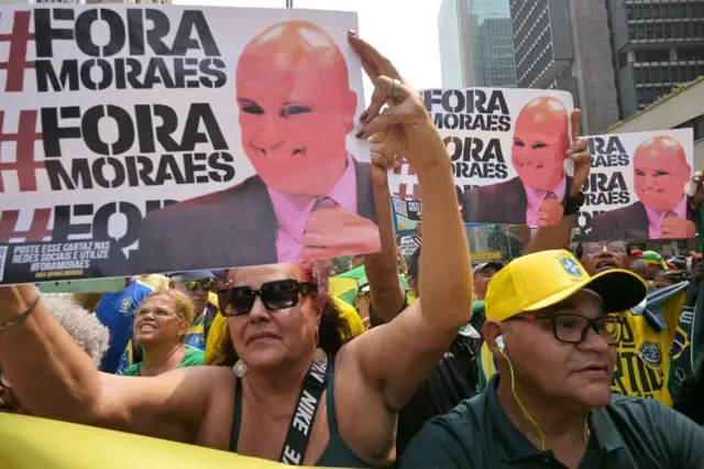 Seguidores de Bolsonaro con carteles que leen "Fuera Moraes", con la imagen del juez Alexandre de Moraes.