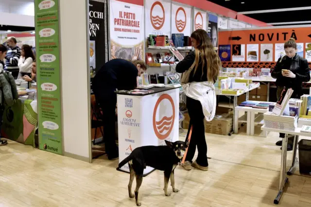 زوار مع كلابهم في أروقة معرض نشر في مدينة روما عام 2023.