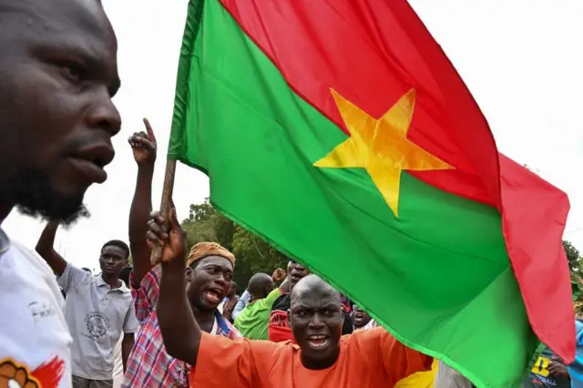 Un homme brandissant le drapeau burkinabè lors d’une manifestation