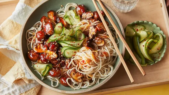 Isahani iteretse ku meza, iteguyeho Noodles, kokombule n'ibihumyo