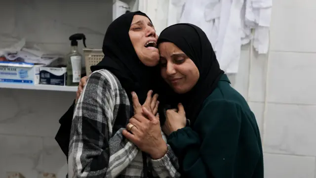 مشيعون يتفاعلون خلال جنازة فلسطينيين، بحسب مسعفين، قُتلوا جراء غارات إسرائيلية يوم السبت، في مستشفى الشفاء بغزة.