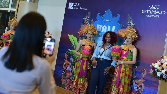 Penumpang pesawat maskapai penerbangan Etihad Airways berfoto dengan penari setelah mendarat perdana di Bandara Internasional I Gusti Ngurah Rai di Badung, Bali, Rabu (26/6/2024). 